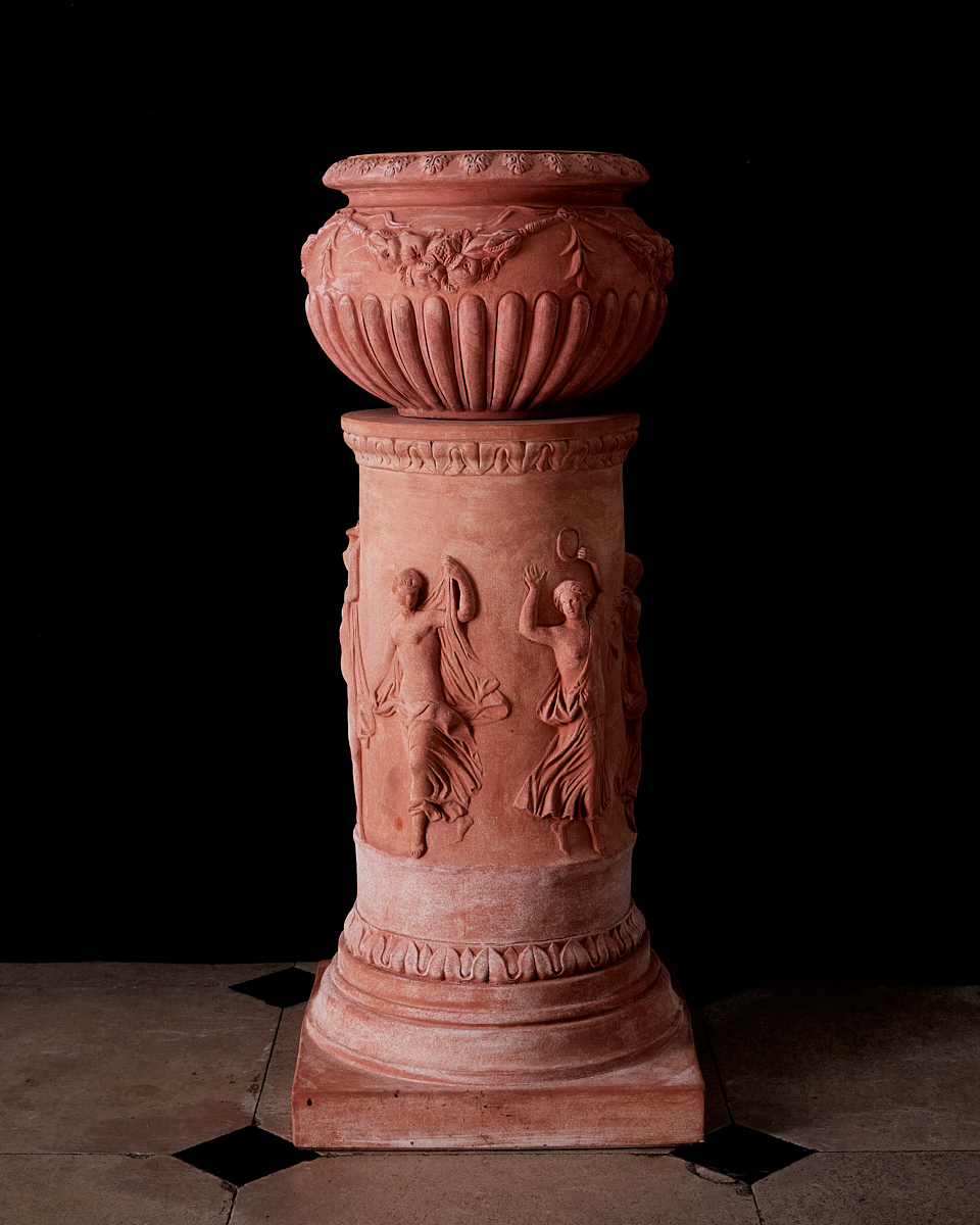 terracotta rounded decorative pot with three angels on terracotta base