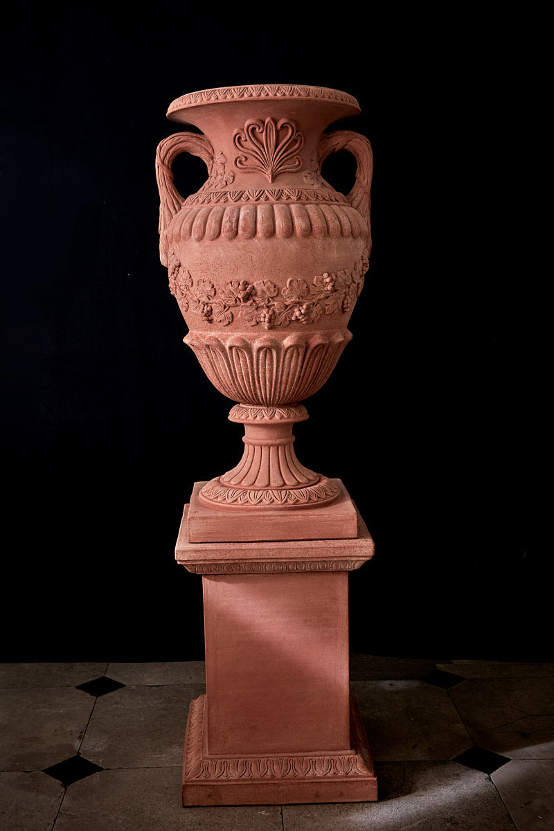 huge terracotta decorative urn with two handles on tall terracotta base